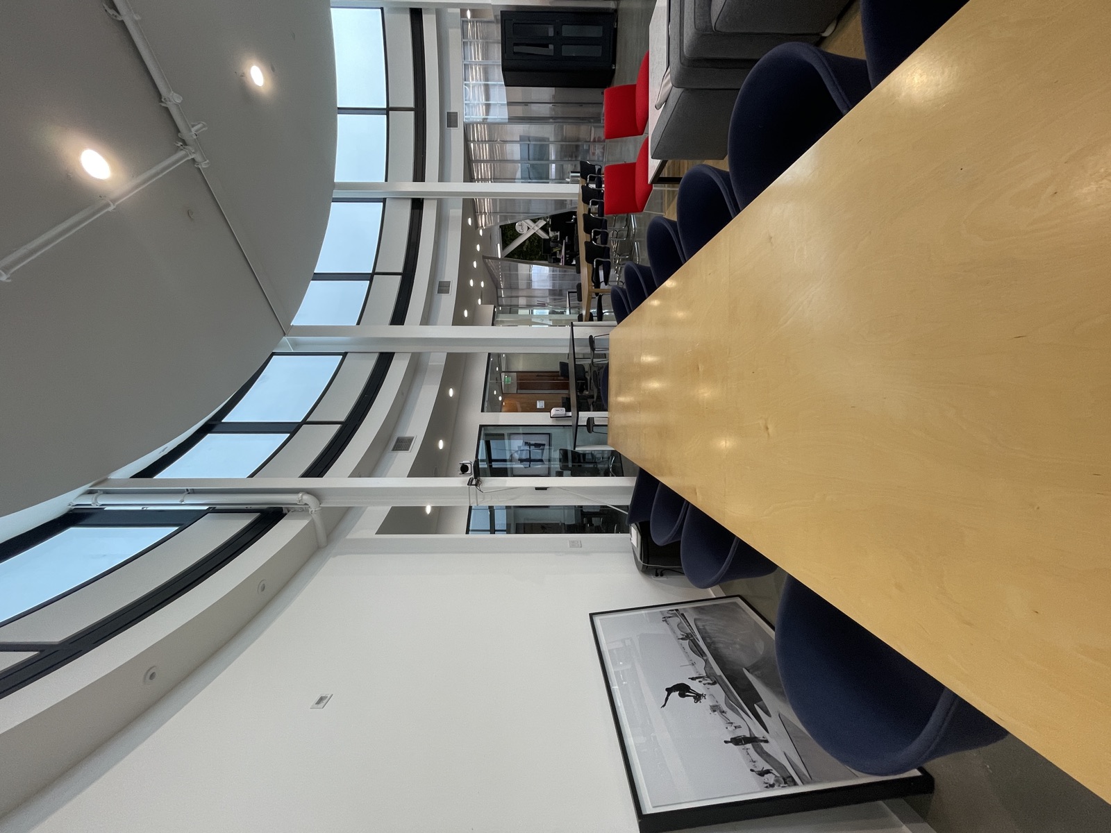 Long communal work table with red chairs